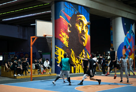Nur-Sultan, Kazakhstan, June 2022. Guys play streetball on the sports ground under a road bridge.のeditorial素材