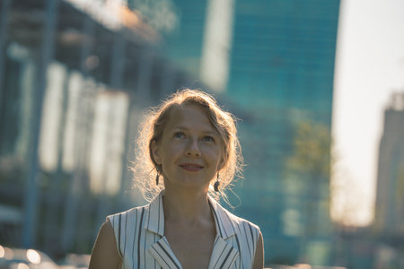 Portrait of a young blonde woman with backlight on the background of buildings. high quality photo