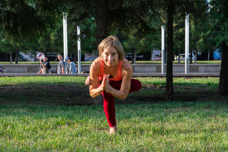 Portrait of a mature woman 59 years old who does yoga on the city street on the lawn. Active sport lifestyle of mature people.の写真素材