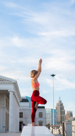 Portrait of a mature woman, 59 years old, doing yoga on a city street. Active sport lifestyle of mature people. Sports in the life of a senior woman.の写真素材