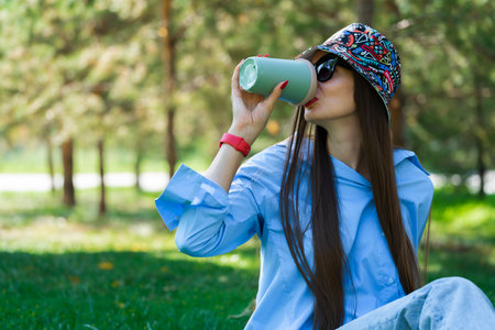 Summer portrait of a girl with long blond hair in sunglasses. A girl in a blue shirt and blue jeans...