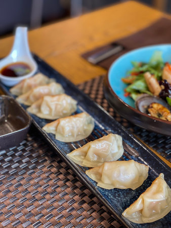 Japanese gyoza dumplings with shrimp on a black platter. High quality photoの写真素材