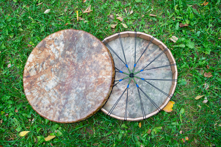 Two Shaman's tambourine made of leather lie on the green grass genuine. High quality photo