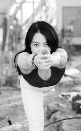 Portrait of a young Asian woman on a green background doing yoga asanas. High quality photoの写真素材