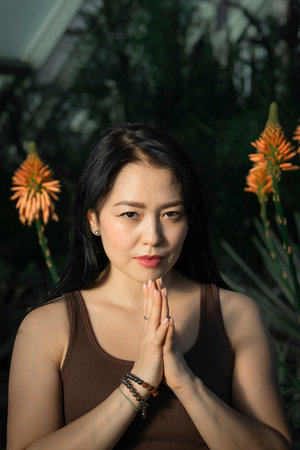 Young Asian woman holds her hands in Namaste pose. High quality photoの写真素材
