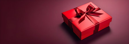 Gift with a red ribbon on a burgundy background, top view. Banner for Valentine's Day, March 8, birthday. High quality photoの素材