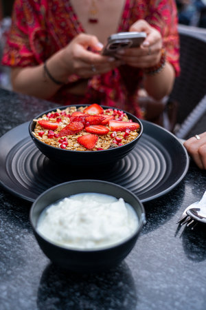 Breakfast granola with yogurt and strawberries on a black plate on a dark background. High quality photoの写真素材