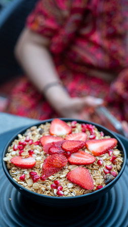 Breakfast granola with yogurt and strawberries on a black plate on a dark background. High quality photoの写真素材