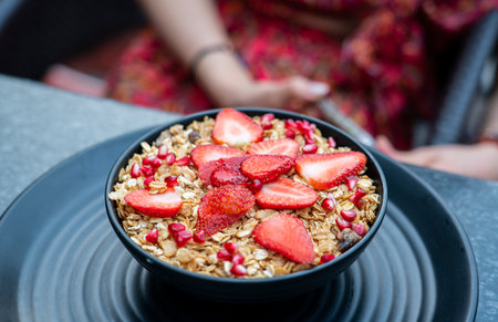 Breakfast granola with yogurt and strawberries on a black plate on a dark background. High quality photoの写真素材