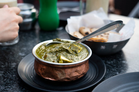 A bowl of Palak Paneer made of Paneer cheese dipped in mildly spiced Spinach gravy on wooden background. High quality photoの写真素材