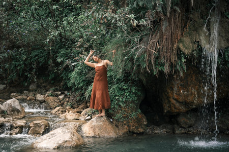Secret Waterfall. A girl in a brown dress against the backdrop of the tropics. High quality photo