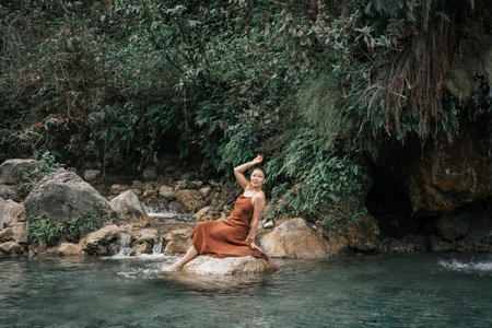 An Asian girl in a brown dress against the backdrop of the tropics.High quality photoの写真素材