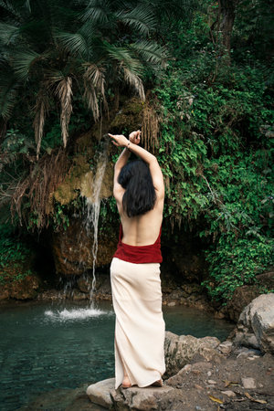 India, Secret Waterfall. An Asian girl against the backdrop of the tropics.High quality photoの写真素材