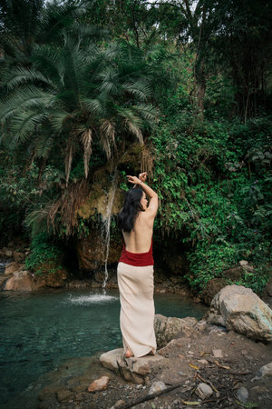 India, Secret Waterfall. An Asian girl against the backdrop of the tropics.High quality photoの写真素材
