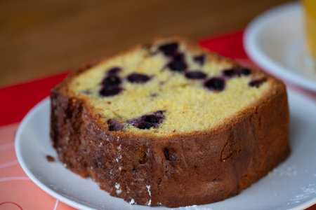 A piece of cake with currants on a plate.の写真素材