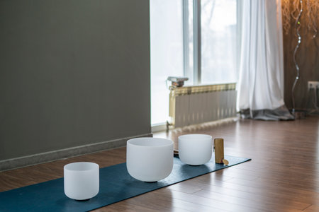 White singing bowls on the floor of a yoga studio.の写真素材