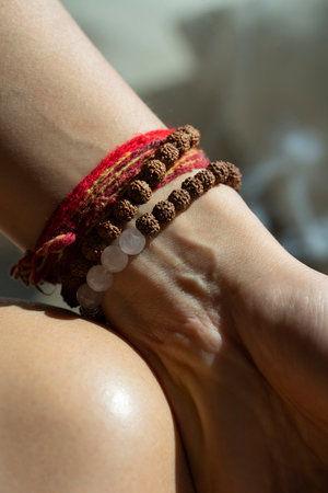 Rudraksha and rose quartz bracelets on womans hand
