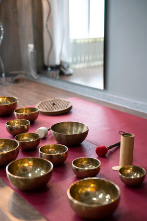 A set of Tibetan singing bowls on the floor of a yoga studio.