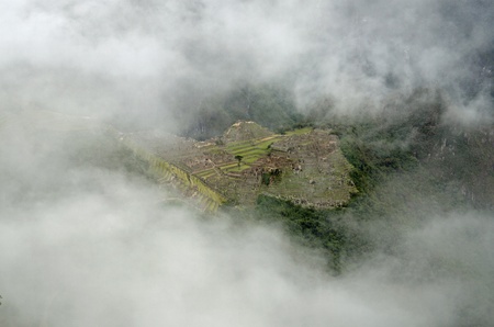 The Inca village of Macchu Picchu seen from the Sun Gate through a hole in the cloudsのeditorial素材