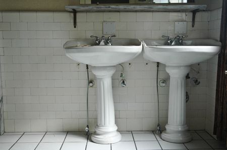 Two antique sinks in a vintage, run-down bathroomの写真素材