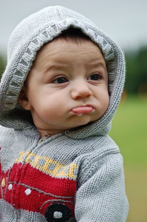 Cute caucasian toddler in a hoodie drooling slightly