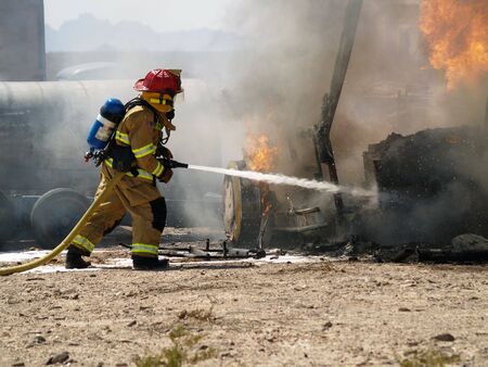 Shot of a firefighter putting out a burning RV.