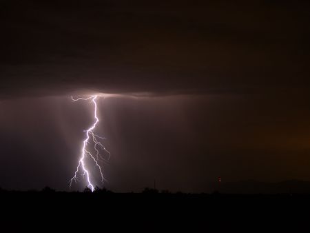 A shot of a big lighting strike in the desert.