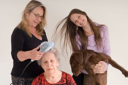 Three generations of women (and a puppy) in one photo. Mother is drying the grandmother's hair