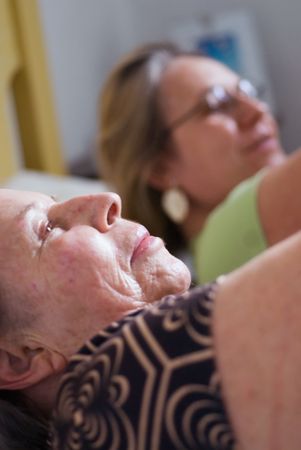 A shot of a grown child stretching with her elderly mother.の写真素材