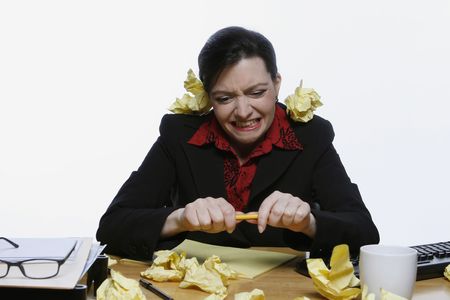 Woman in a business suit balancing a pencil under her nose surrounded by crumpled up pieces of yellow paper. Isolated against a white backgroundの写真素材
