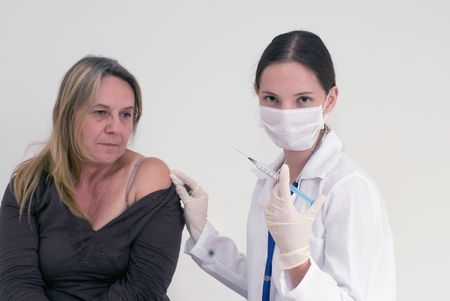 A shot of a female nurse about to give female patient a shot.の写真素材