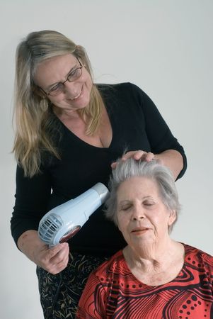 A shot of an adult child doing her elderly mother's hair.の写真素材