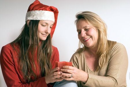 Mature woman and her daughter getting into the christmas spirit and holding a burning christmas candle.の写真素材