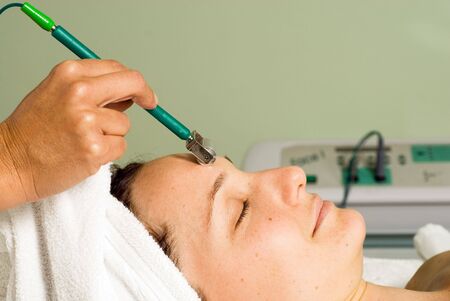 Woman lying down getting a facial. Horizontally framed photograph.