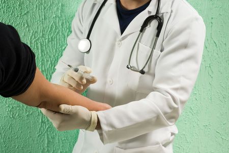 A doctor, holds a syringe near a patients outstretched arm, preparing to administer the injection. -...