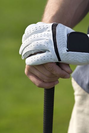 Man's hands resting on golf club - Vertically framed photoの写真素材