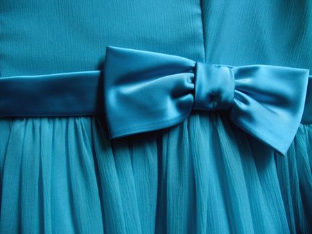 A turquoise bow is tied onto a piece of fabric - Horizontally framed shot.の写真素材