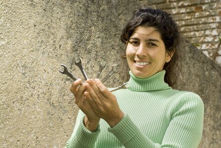 Smiling woman holding five wrenches. Vertically framed photo.の写真素材