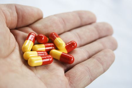 Yellow and Red pills in the hand of a patient.  To take or not to take.の写真素材