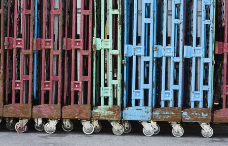 A line of old trolleys.  They are weathered but they still have attractive colours.  Could be used for transferring or transporting stuff.の写真素材