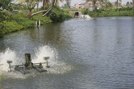 A shrimp farm with a water machine aerating the water.  Shrimp farming is popular in Taiwan. の写真素材