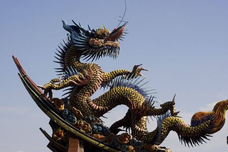 A traditional dragon sculpture with lots of movement.  This is on top of a temple.