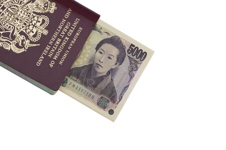 A passport with some Japanese money sticking out.  They have been isolated from the background. ...