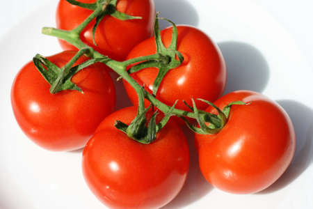 Ripe Tomatoes on a white plate.  They are ready to eatの写真素材