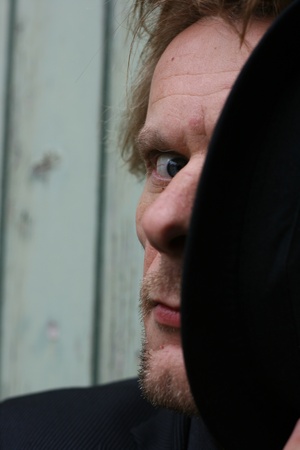 I can see you!  A man with a black hat that covers half his face looks at you directly. The eye is very intense.の写真素材