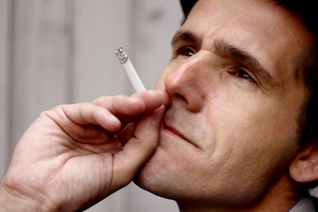 Man smoking a cigarette and deep in thoughtの写真素材