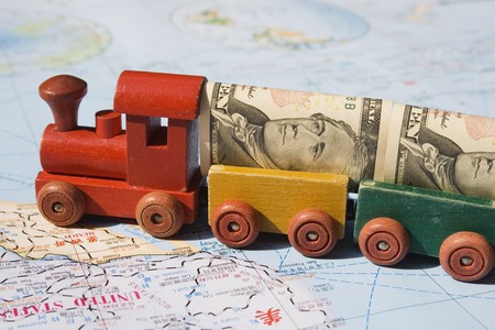A toy train, loaded with US dollars going to North America.  The concept is trade between nations, international trade.  The train represents movement, the money transactions and the map, well the world.のeditorial素材