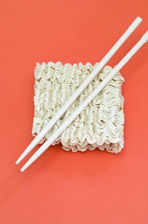 block of instant noodles and chopsticksの写真素材
