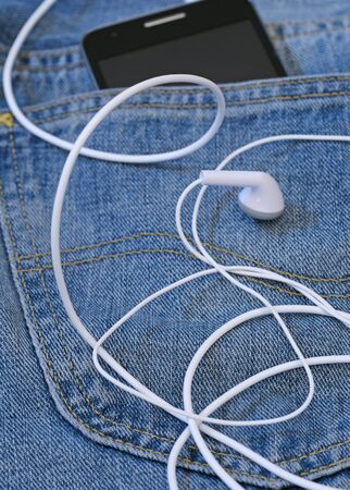 smartphone with earphones in pocketの写真素材