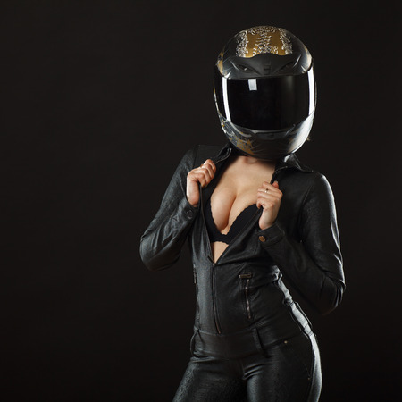 biker girl posing in studio in black background biker girl posing in studio in black background